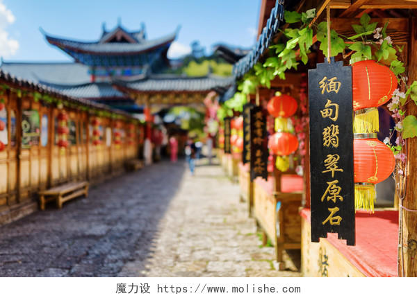 蓝色天空下一排排中国传统灯笼和黑色木板的丽江老城风景图